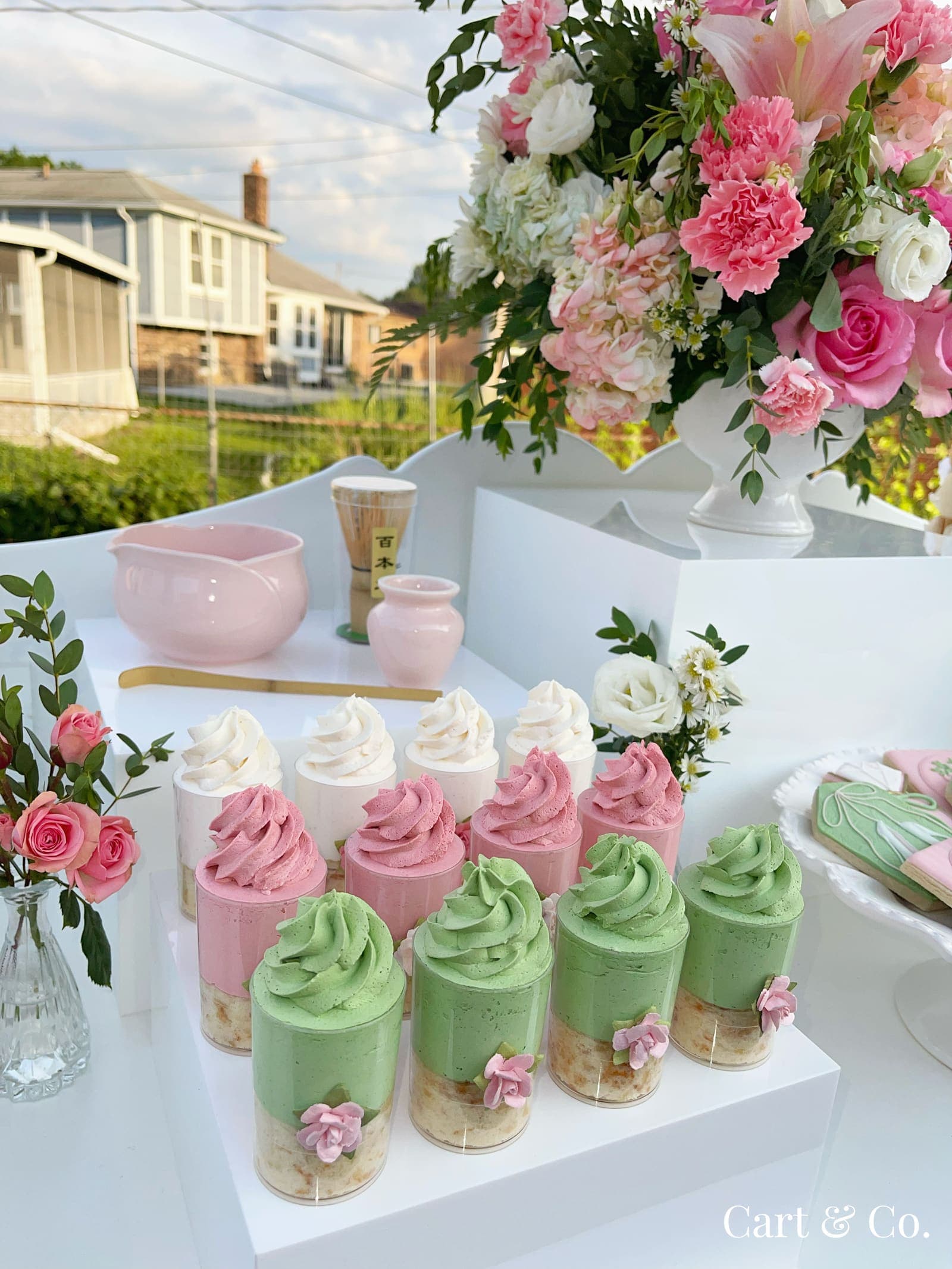 Close-up of a matcha ceremony set with pink and green mousse cups, styled for a rooftop bridal shower at sunset