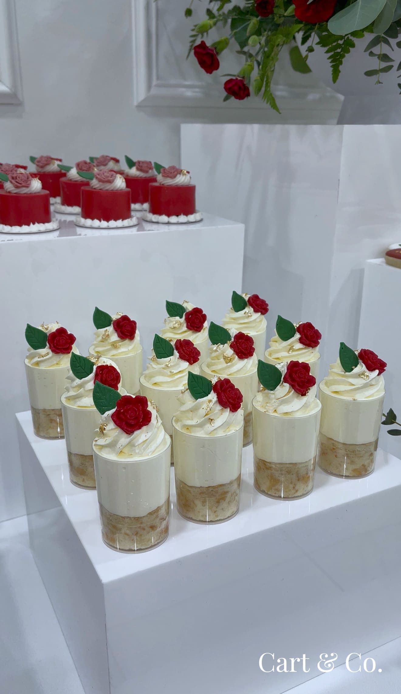 Cream mousse cups topped with sugar roses and mint leaves, finished with gold leaf