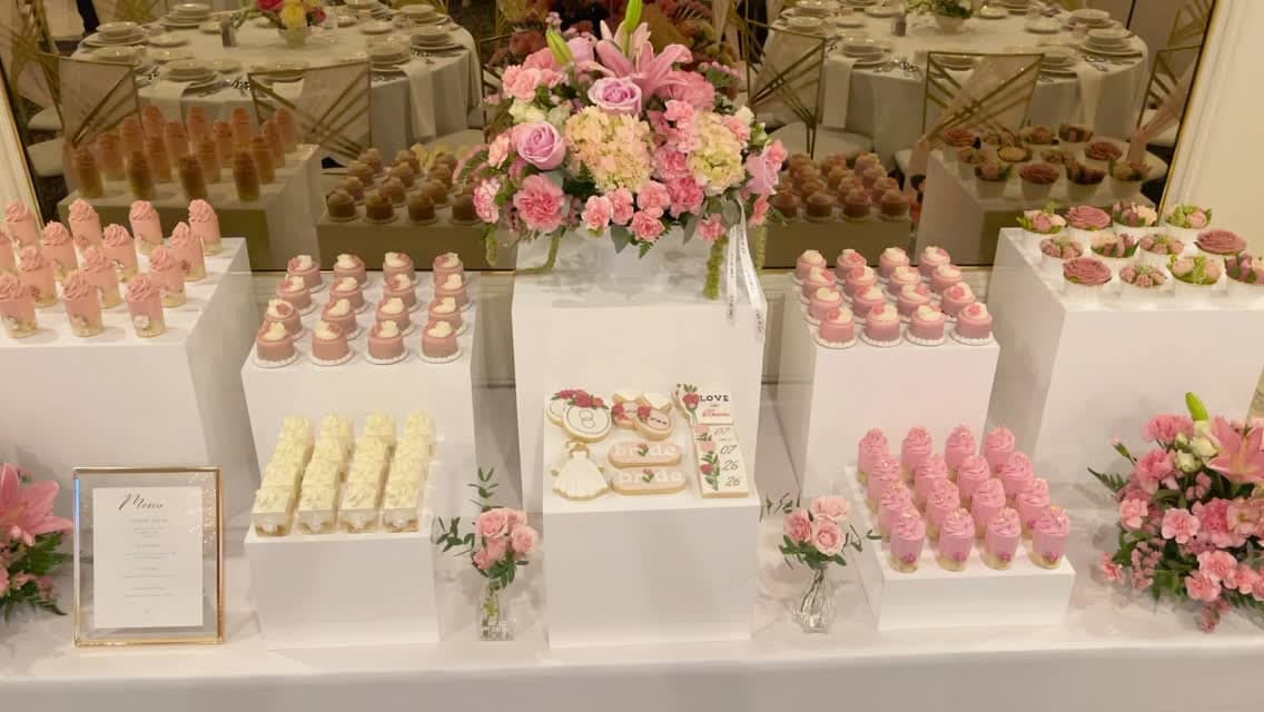 Tiered pink and white dessert stands with mini cakes, mousse cups and fresh floral arrangements styled by Cart & Co.