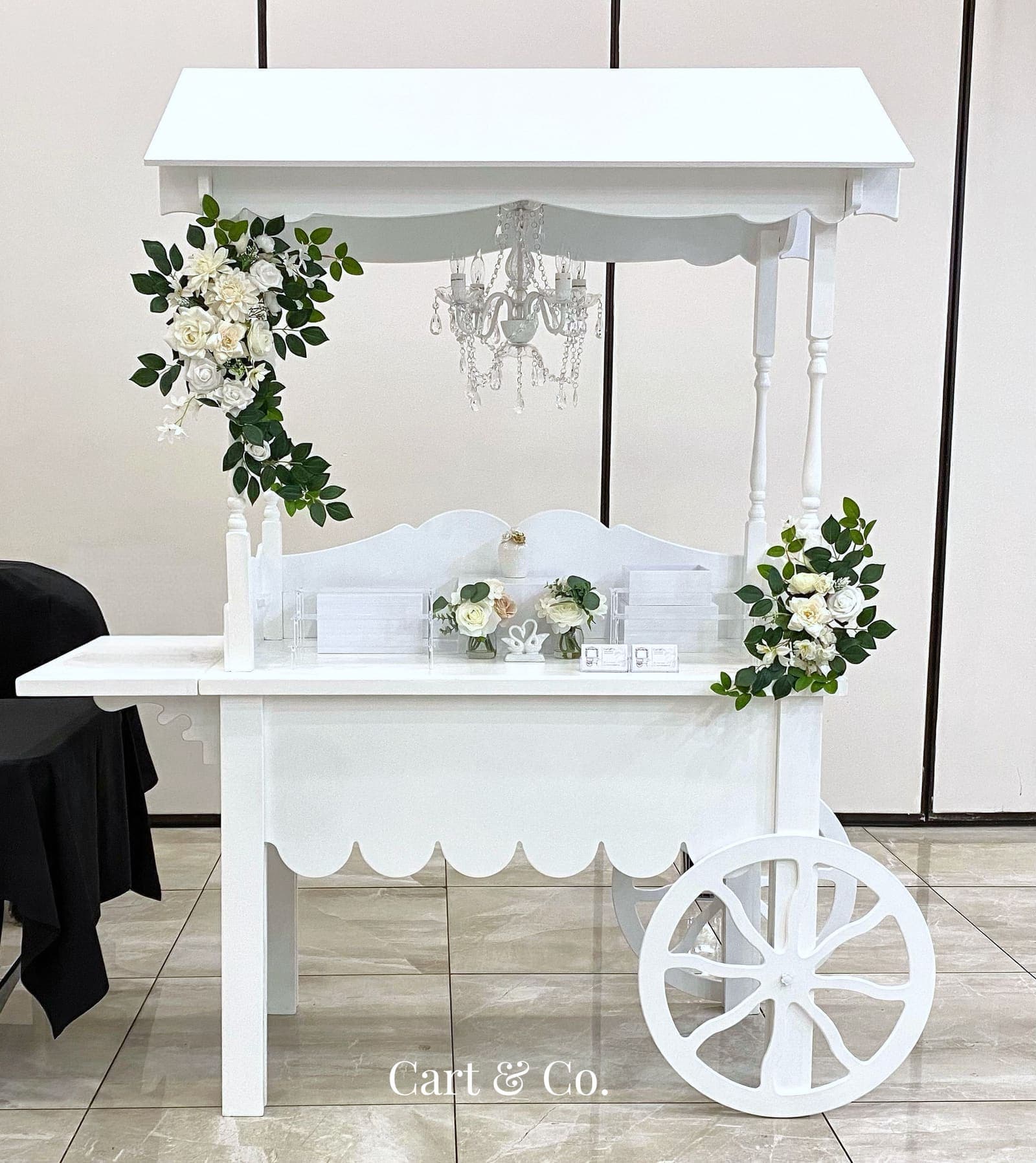 The Signature Cart, styled for a Peter Rabbit-themed baby shower with a pastel floral arrangement, a storybook and carrots on the counter
